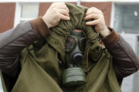 A man wears a gas mask during a protest against Chevron's plans to explore for shale gas in Barlad